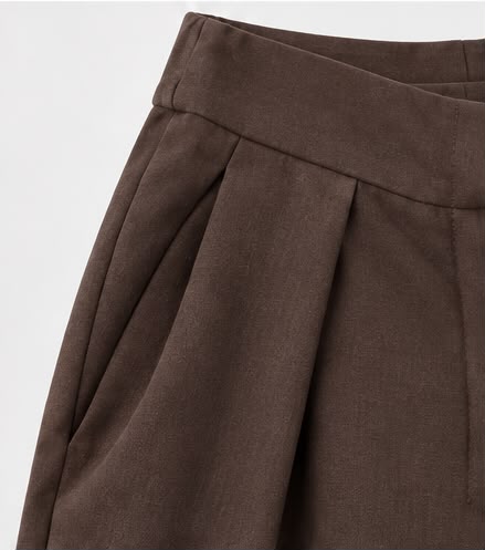Detalle de la pinza y el bolsillo del pantalón marrón