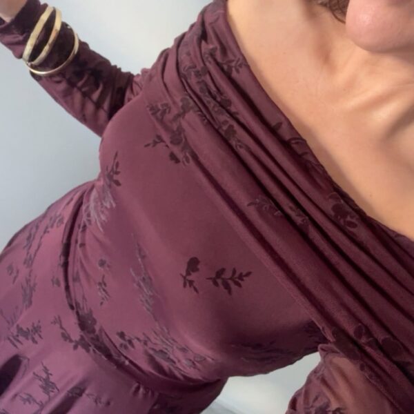 Detalle del top combinado berenjena de hombros descubiertos